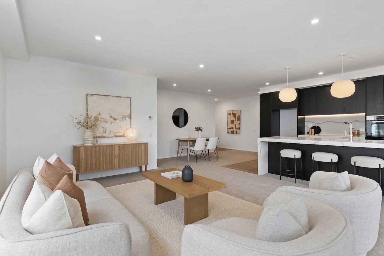 Open-plan living, dining and kitchen scheme with neutral seating and black cabinetry